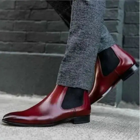 Oxblood leather Chelsea boot in motion showing elastic gusset and leather shine