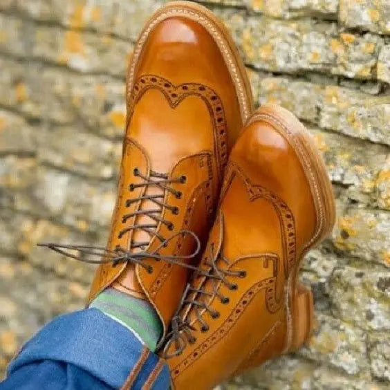 Tan leather wingtip brogue boots showing perforated detailing