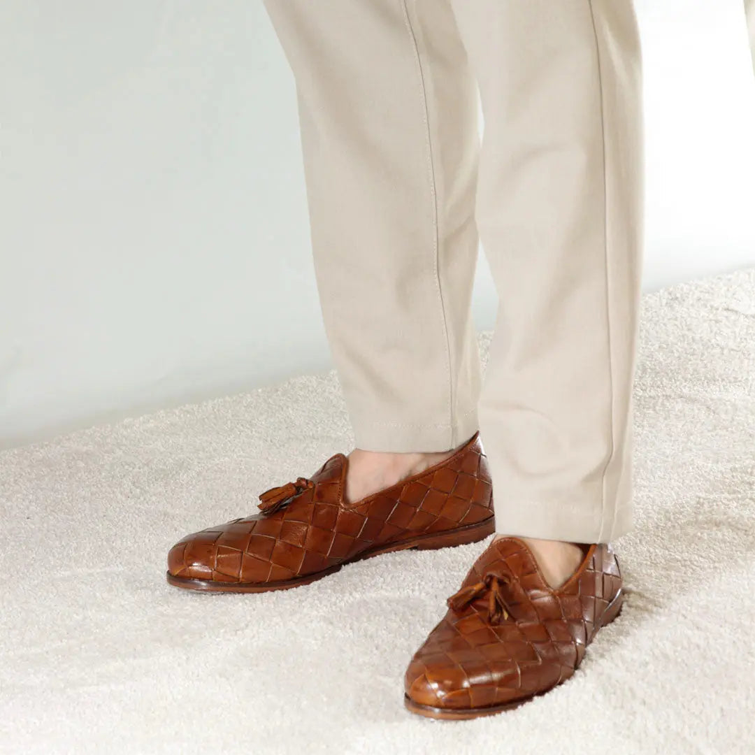 Brown woven leather tassel loafers worn with cream 